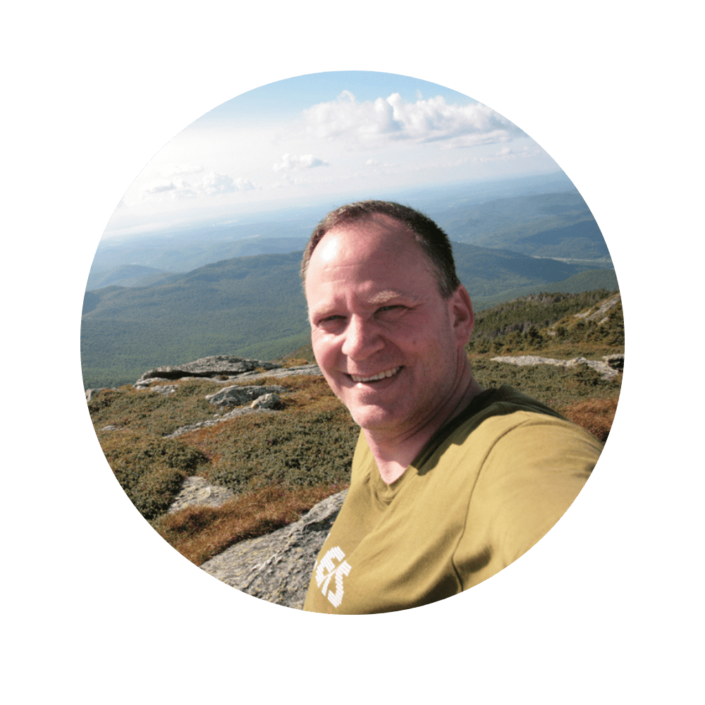 A selfie photograph of Peter Kelly on top of a mountain.