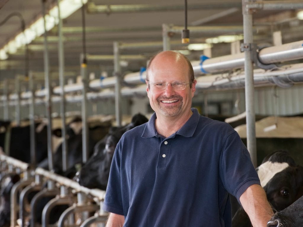 A headshot of Dr. David Kelton in a Dairy farm