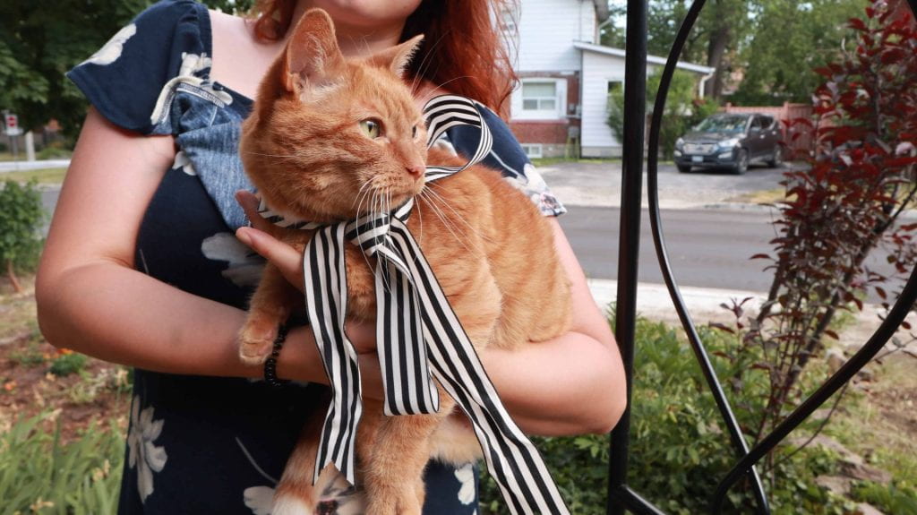Photograph of Sophie Neumann holding her orange tabby cat.