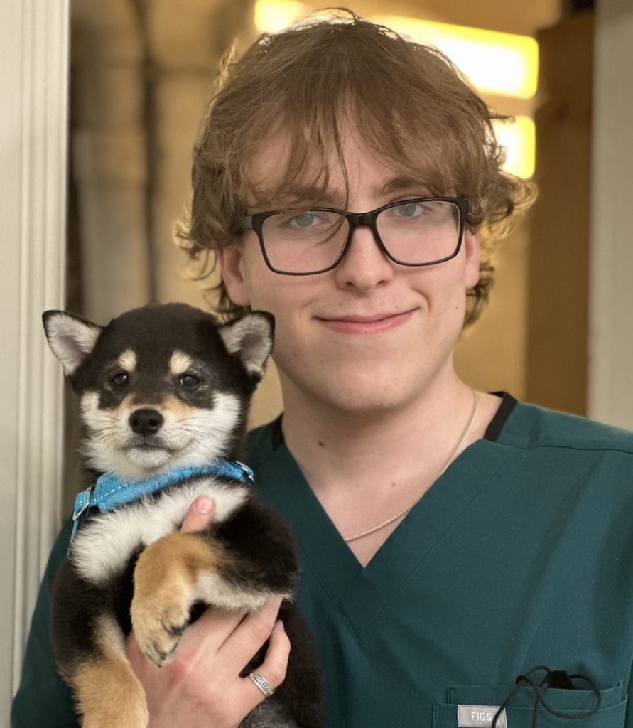 A headshot of Kyle holding a dog.